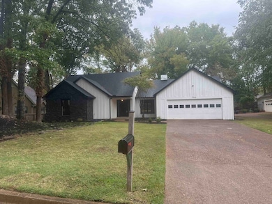 Modern inspired farmhouse with a front lawn, board and batten siding, driveway, and a garage