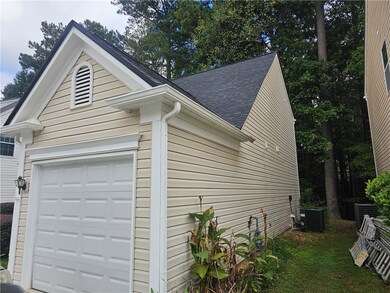 View of side of property with a shingled roof and a central air condition unit