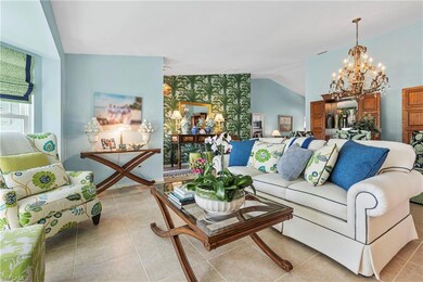 Living room with a chandelier, light tile patterned floors, and lofted ceiling