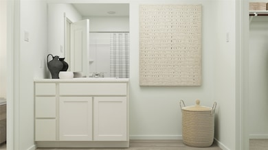 Bathroom featuring a shower with curtain, vanity, and light wood-type flooring