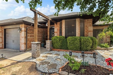 Ranch-style house featuring brick siding, a garage, roof with shingles, and driveway