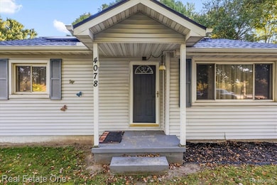 Property entrance with a shingled roof and a porch