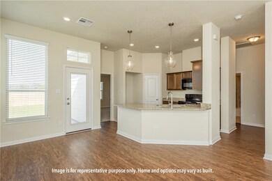 Kitchen with hanging light fixtures, light stone countertops, black appliances, dark wood-type flooring, and a peninsula