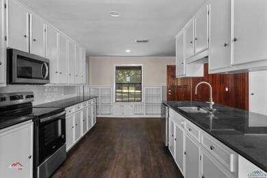 Kitchen with dark wood-type flooring, appliances w