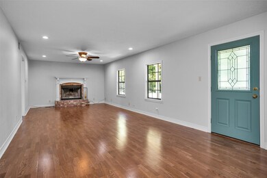 AS YOU ENTER THE HOME YOU WILL FIND THIS OVERSIZED LIVING AREA WITH THE WOOD BURNING FIREPLACE AND WOOD LAMINATE FLOORING.