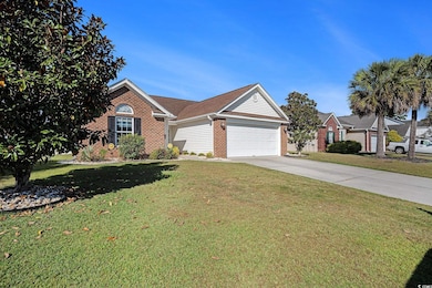 View of front of house with brick siding, driveway, a front yard, a garage, and a shingled roof