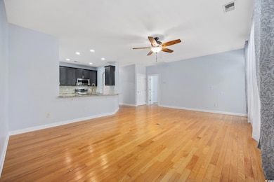 Unfurnished living room featuring a ceiling fan, l