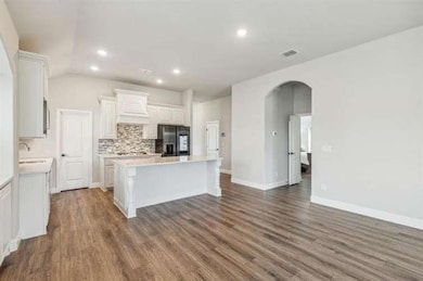 Kitchen with a kitchen island, white cabinets, sta