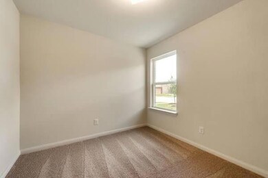 Carpeted spare room featuring baseboards