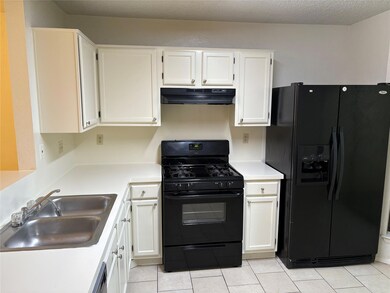 Kitchen featuring a sink, under cabinet range hoo