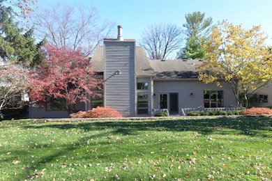 Rear elevation of Bentwood Court. Walk out from dining room out to rear deck... Chimney at high point on roof is the great room with the 22-foot high vault and wall of windows...