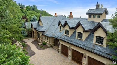 View of front of house featuring a high end roof, stucco siding, and stone siding