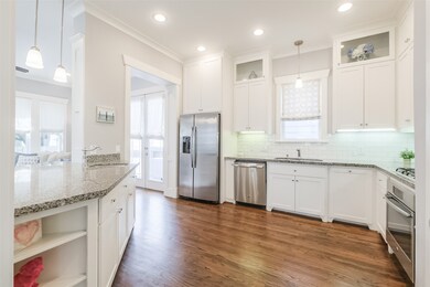 The island kitchen features granite counters with