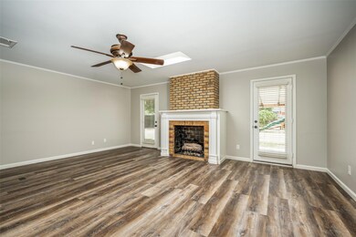 Unfurnished living room with a healthy amount of sunlight, wood-type flooring, a fireplace, and ceiling fan