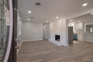 Unfurnished living room featuring wood finished fl