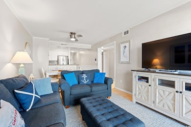 Living room with ornamental molding, a ceiling fan, light tile patterned floors, and baseboards
