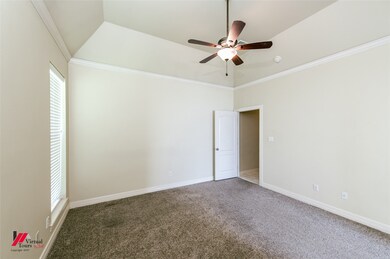 Unfurnished room featuring a ceiling fan, carpet floors, healthy amount of natural light, and ornamental molding