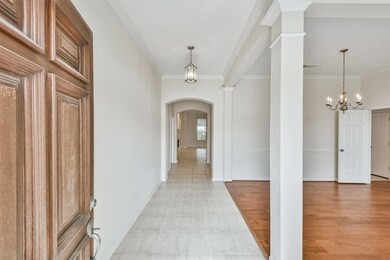 Welcoming tiled entry with high ceiling and crown molding