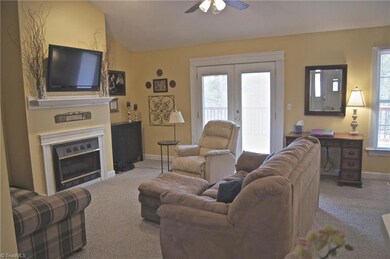 Living Room with Gas Log Fireplace, Carpet, Mounted Flat Screen to remain, Double Doors to spacious deck., Vaulted with overhead ceiling fan & light kit