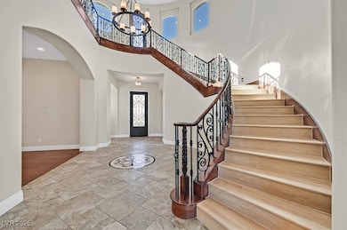 Entrance foyer featuring a chandelier, stone tile