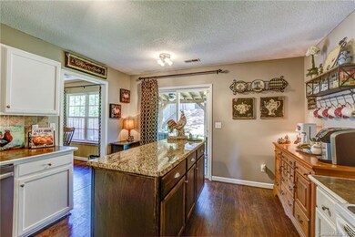 Kitchen has painted white cabinets and work island