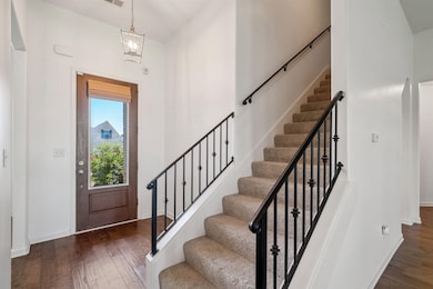 Entryway with dark wood-type flooring, stairs, and baseboards