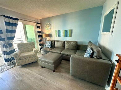 Living area featuring wood finished floors and a textured ceiling