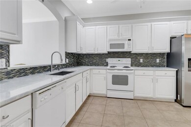 Kitchen with tasteful backsplash, white appliances