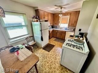 Kitchen with light tile flooring, fridge, range, b