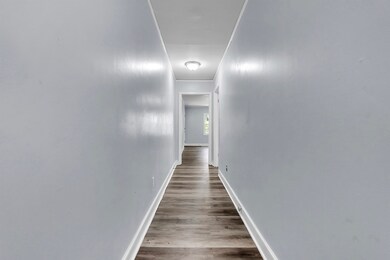 Corridor featuring baseboards, wood finished floor