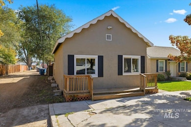 Back of house featuring a wooden deck and stucco siding