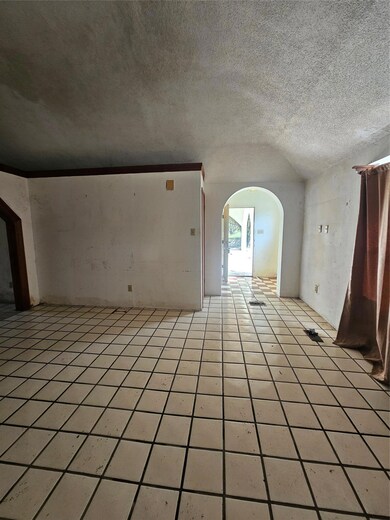 Unfurnished room with arched walkways, vaulted ce