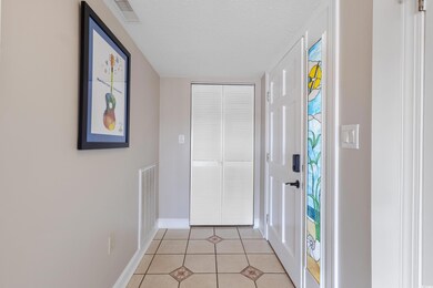 Entrance foyer with light tile patterned floors and a textured ceiling