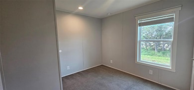 Carpeted empty room featuring baseboards and rece