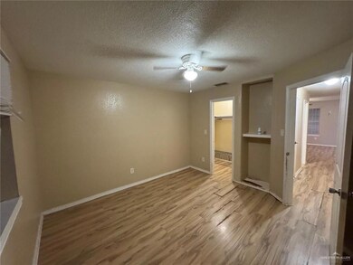 Unfurnished bedroom with visible vents, a textured ceiling, light wood-style floors, baseboards, and ceiling fan
