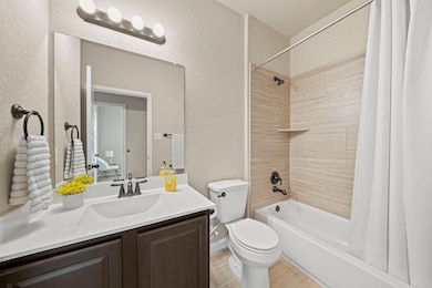 Full bathroom with a textured wall, shower / bath