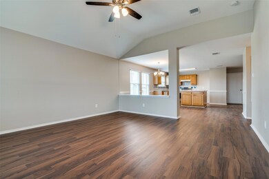 This view is from the backdoor looking into the home.  You can see the front entry, the open-concept floorplan, the spacious kitchen, the dining area, and the large living area with new fan. All freshly painted with new floors.