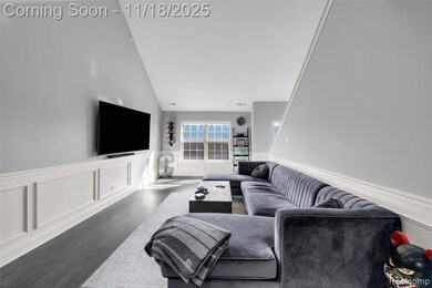 Living area featuring wood finished floors, wainscoting, a decorative wall, and high vaulted ceiling
