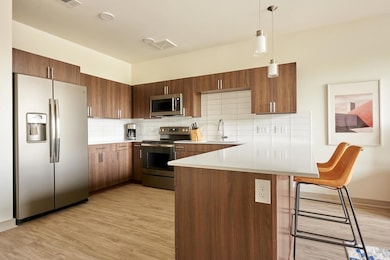 Kitchen featuring light wood finished floors, bac