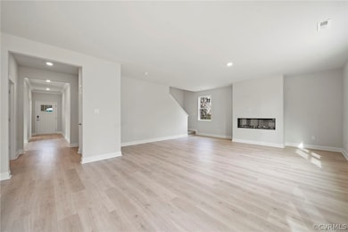 Unfurnished living room featuring light hardwood /
