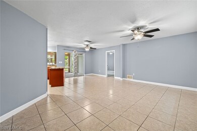 Empty room with light tile patterned floors, a textured ceiling, and ceiling fan