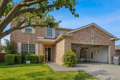 Traditional-style home featuring brick siding, concrete driveway, an attached garage, a front lawn, and gas water heater