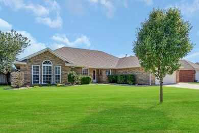 Ranch-style home with a garage and a front lawn