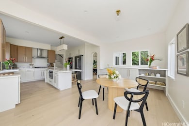 An airy, light-filled kitchen unfolds with a sculptural waterfall-edge island, a generous farmhouse sink, and effortless space for lingering over morning coffee.