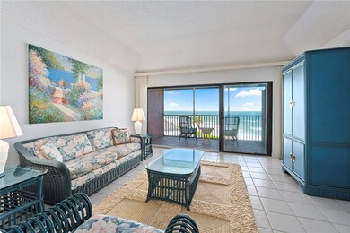 Living room with a water view, light tile patterned floors, a textured ceiling, and lofted ceiling