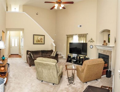The great room showcases soaring ceilings with fan