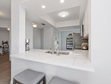 Kitchen with light stone counters, sink, hardwood 