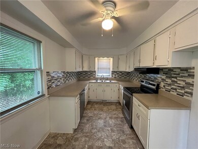 Kitchen featuring ceiling fan, stainless steel appliances, a wealth of natural light, and backsplash