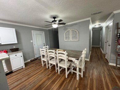 Dining space featuring a textured ceiling, dark ha