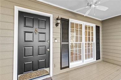 Entrance to property featuring a ceiling fan